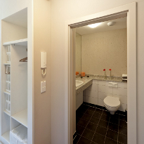 Musterapartment: der Einbauschrank und der Blick ins Bad mit Waschtisch aus Granit und großem Spiegel.